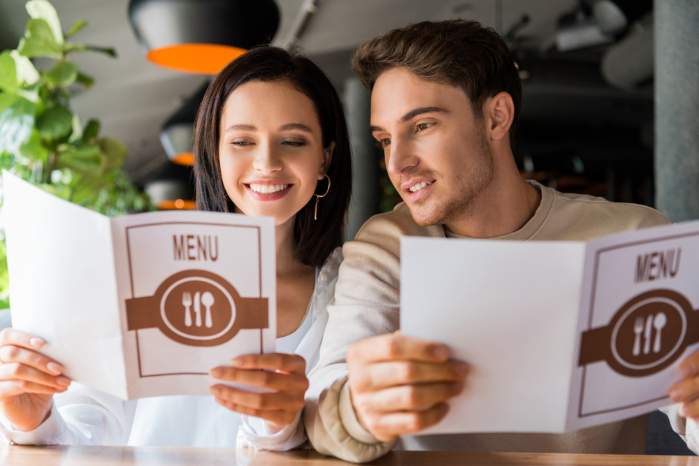 Selective,Focus,Of,Man,And,Happy,Woman,Looking,At,Menus