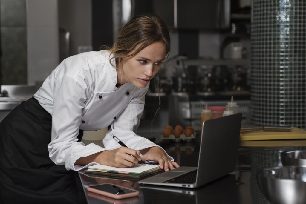 female-chef-kitchen-using-laptop-device